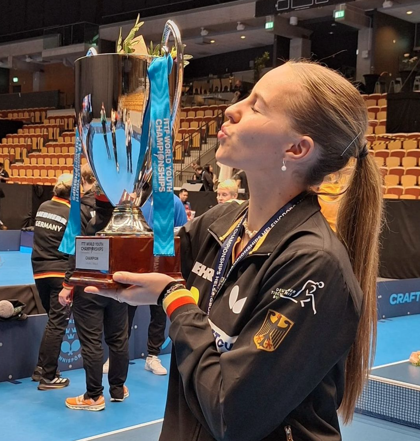 Annett Kaufmann mit Weltmeister-Pokal in den Händen, gibt einen Kuss in die Luft