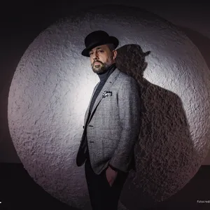 Rapper und Agenturbesitzer das Bo, mit Hut in einem Scheinwerferkegel