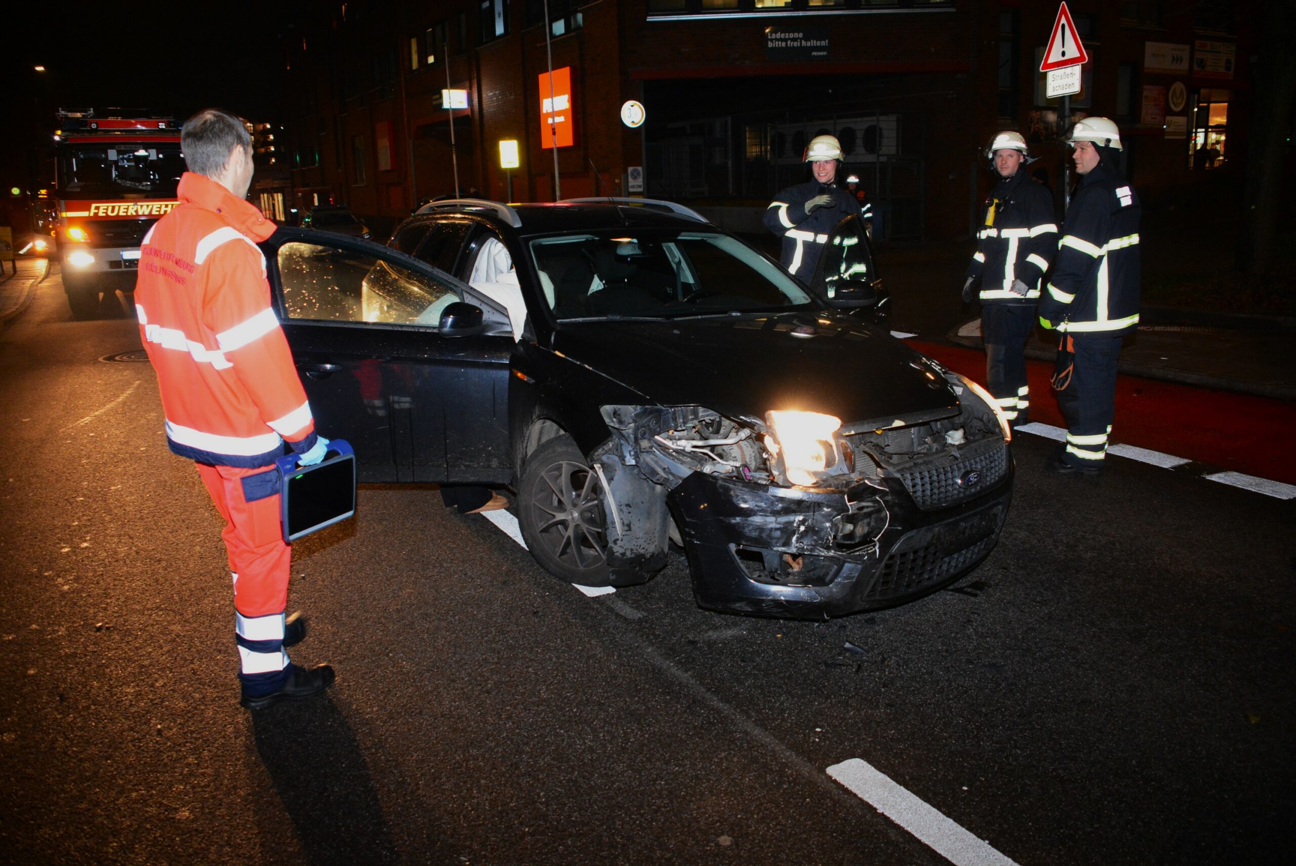 Feuerwehrleute sichern die Unfallstelle in Lohbrügge nach der Kollision zweier Pkw.