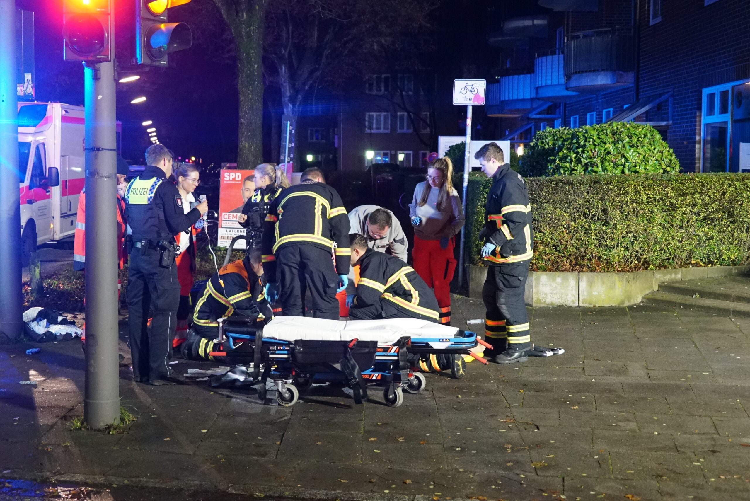 Rettungskräfte versorgen die am Boden liegende Frau.