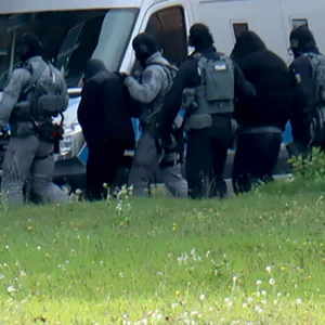 Polizisten vor Polizeiwagen