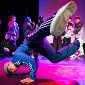 Ein Breakdancer, bei lila Licht am Performen auf Kampnagel