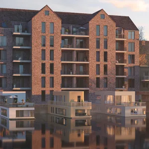 Ein Backsteingebäude an einem Kanal mit Hausbooten davor