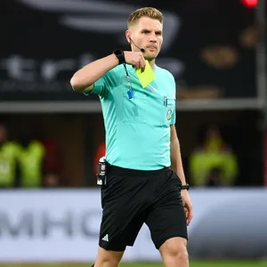 Schiedsrichter Timo Gerach zeigt eine Gelbe Karte