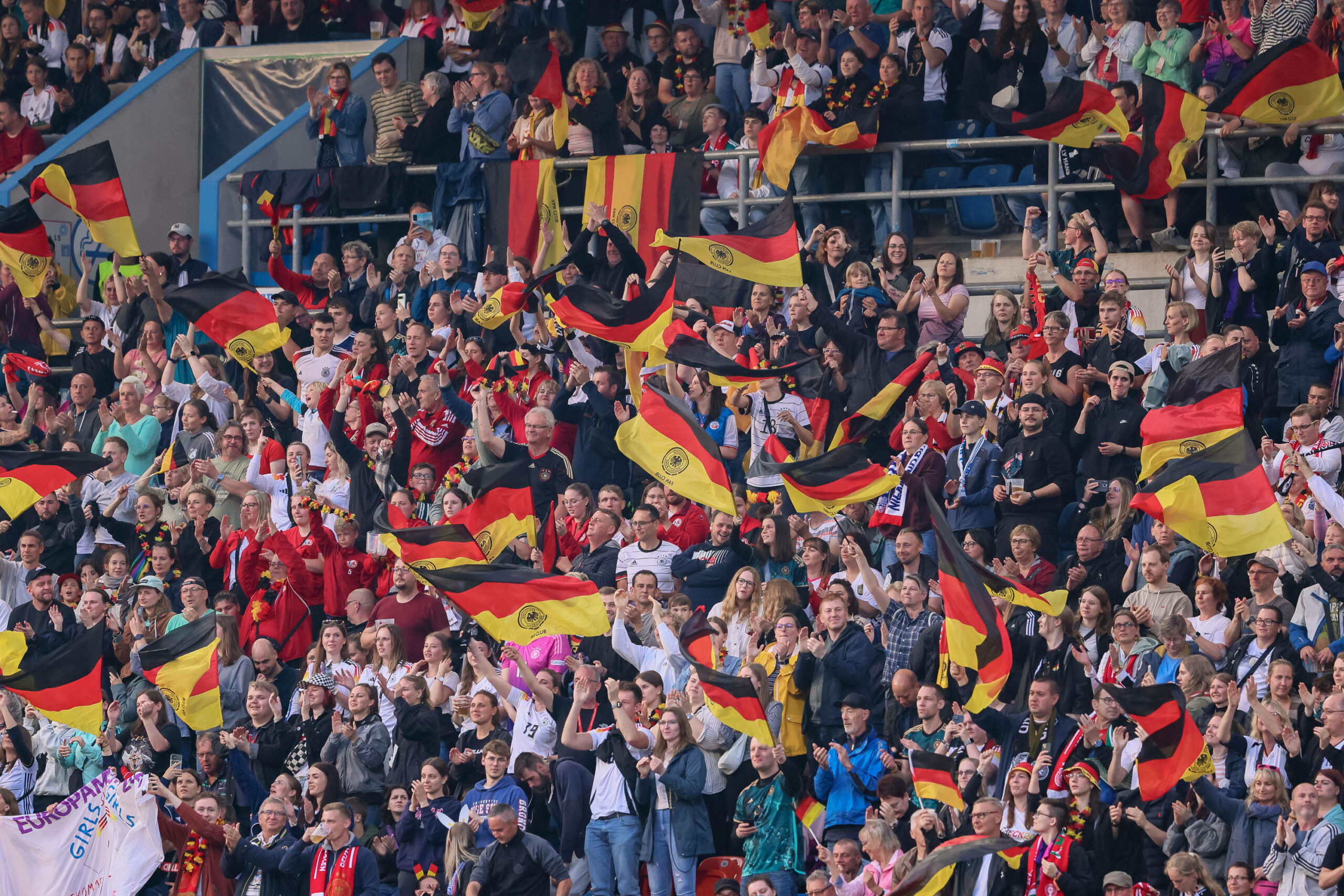 Fans der deutschen Frauen-Fußballnationalmannschaft schwenken Nationalfahnen