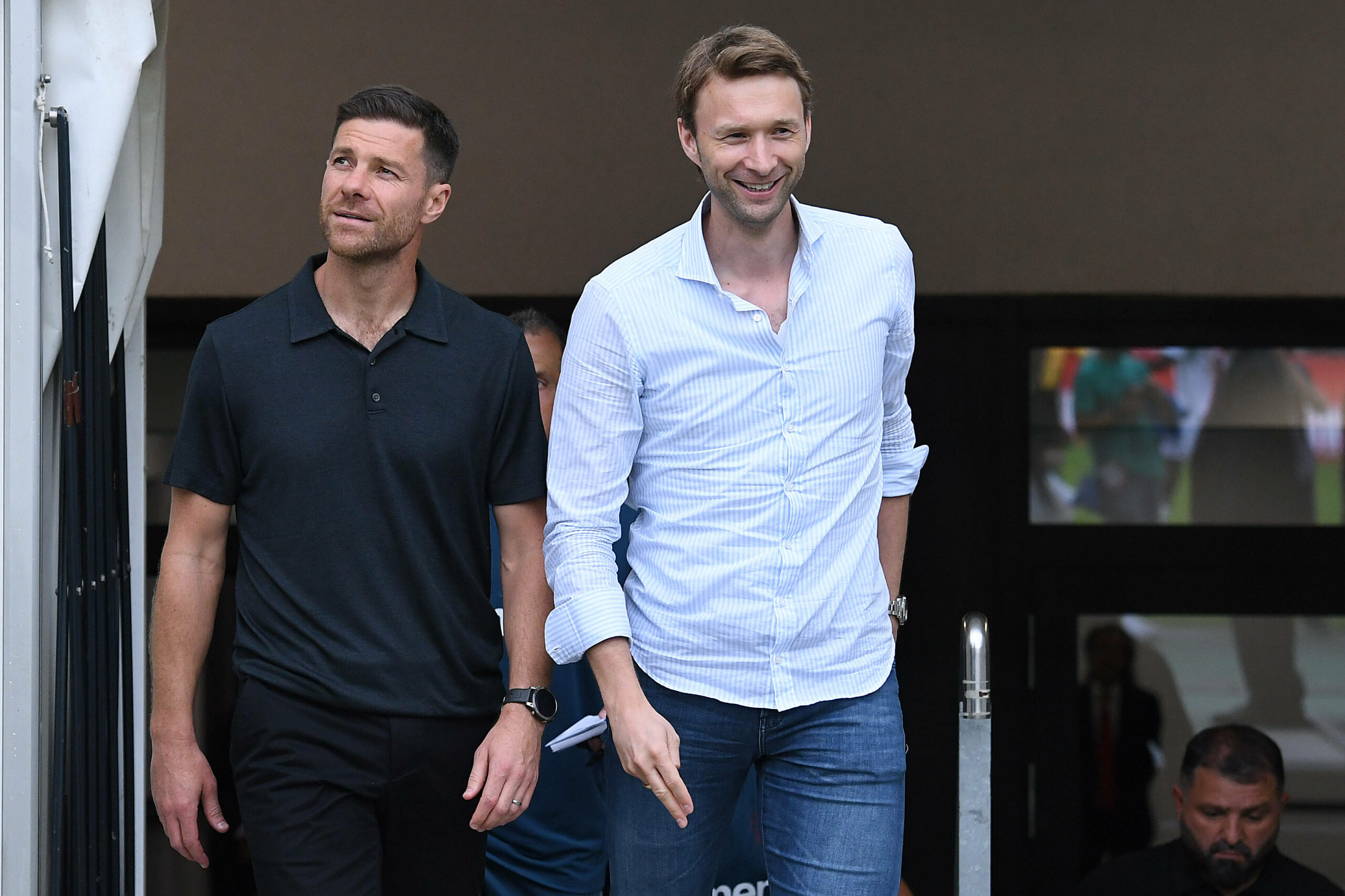 Xabi Alonso und Simon Rolfes gehen lächelnd nebeneinander