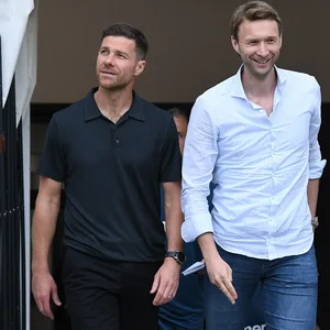 Xabi Alonso und Simon Rolfes gehen lächelnd nebeneinander