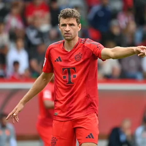 Thomas Müller streckt den Arm auf dem Spielfeld raus