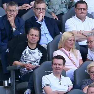 Jan-Christian Dreesen sitzt auf der Tribüne zwischen Herbert Hainer und Max Eberl