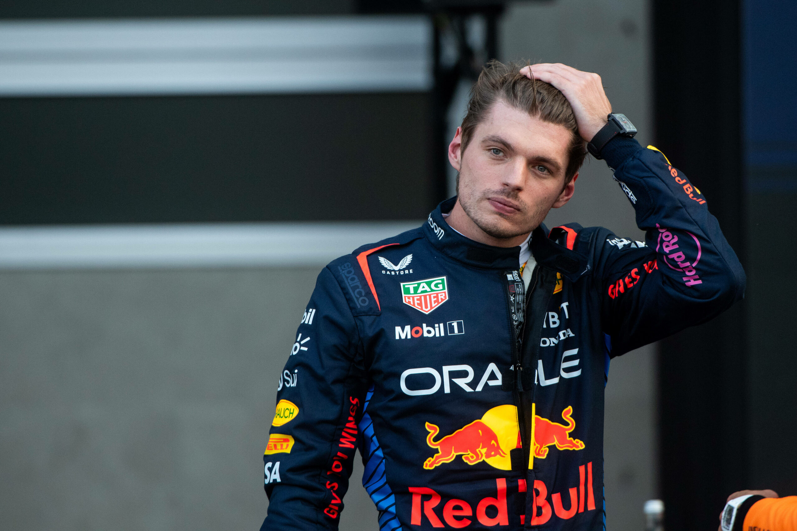 Max Verstappen in Red-Bull-Anzug fährt sich durch die Haare