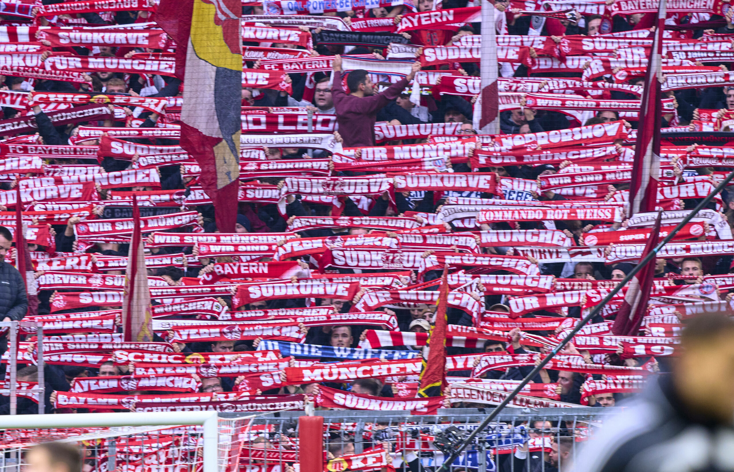 Bayern München Fans halten ihren Schal nach oben