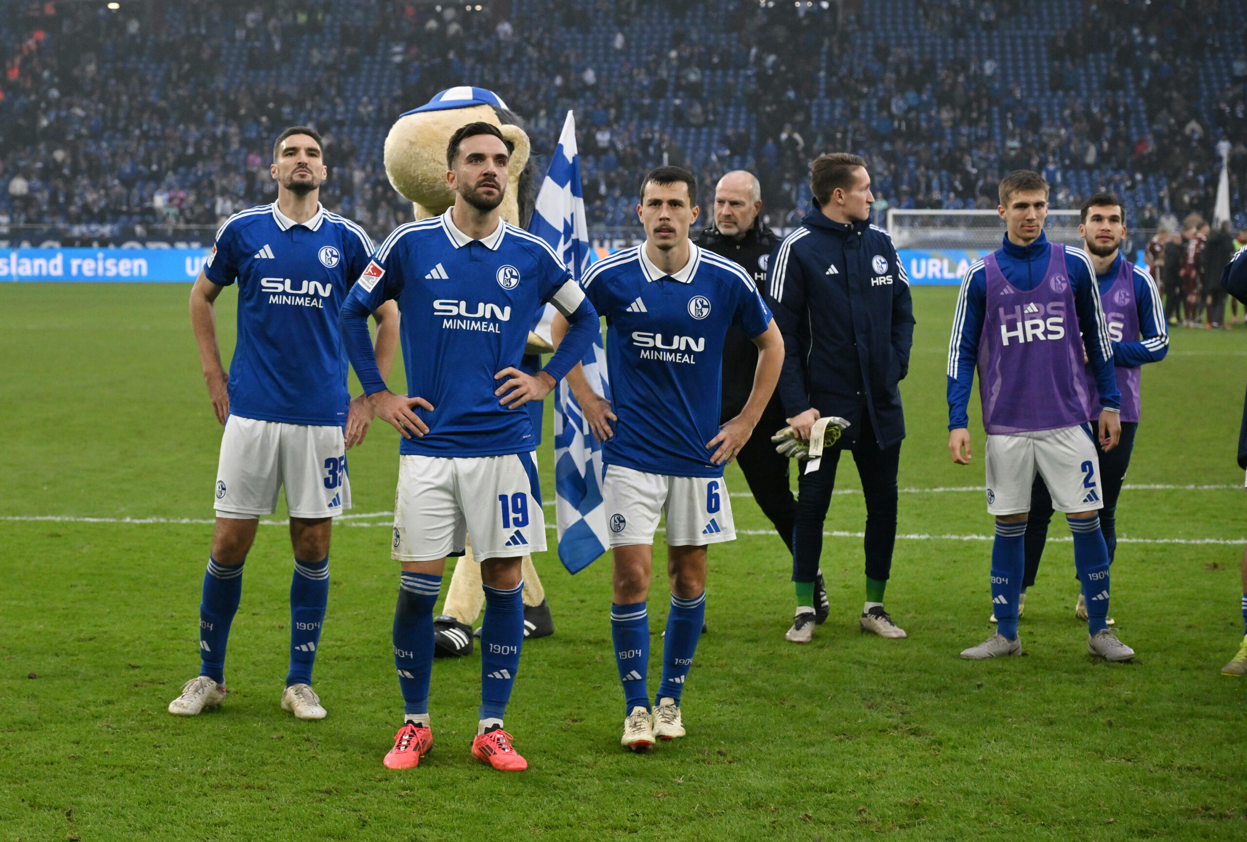 Marcin Kaminski, Kenan Karaman und Ron Schallenberg gehen vor der restlichen Mannschaft des FC Schalke 04 in Richtung Tribüne, gucken enttäuscht