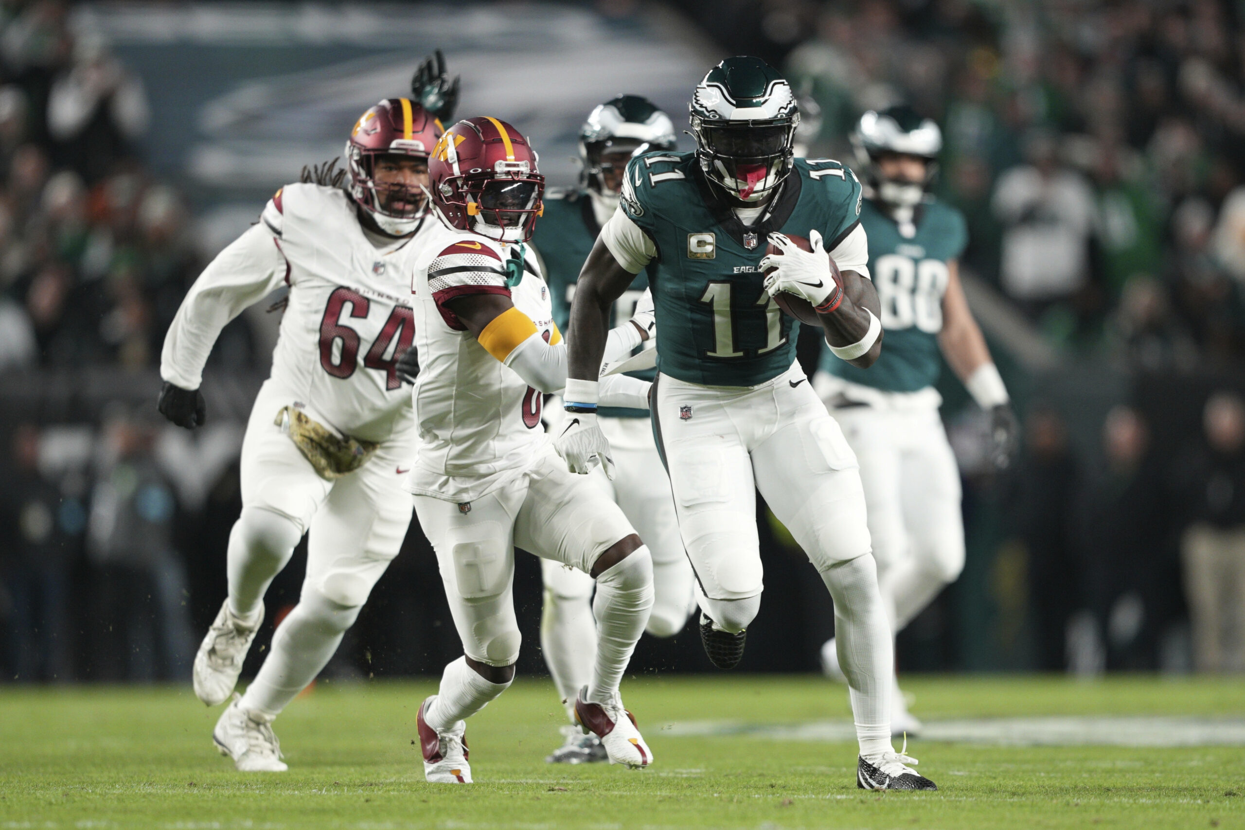 Philadelphia Eagles' Wide Receiver A.J. Brown läuft mit Ball in der Hand vor Spielern der Washington Commanders weg