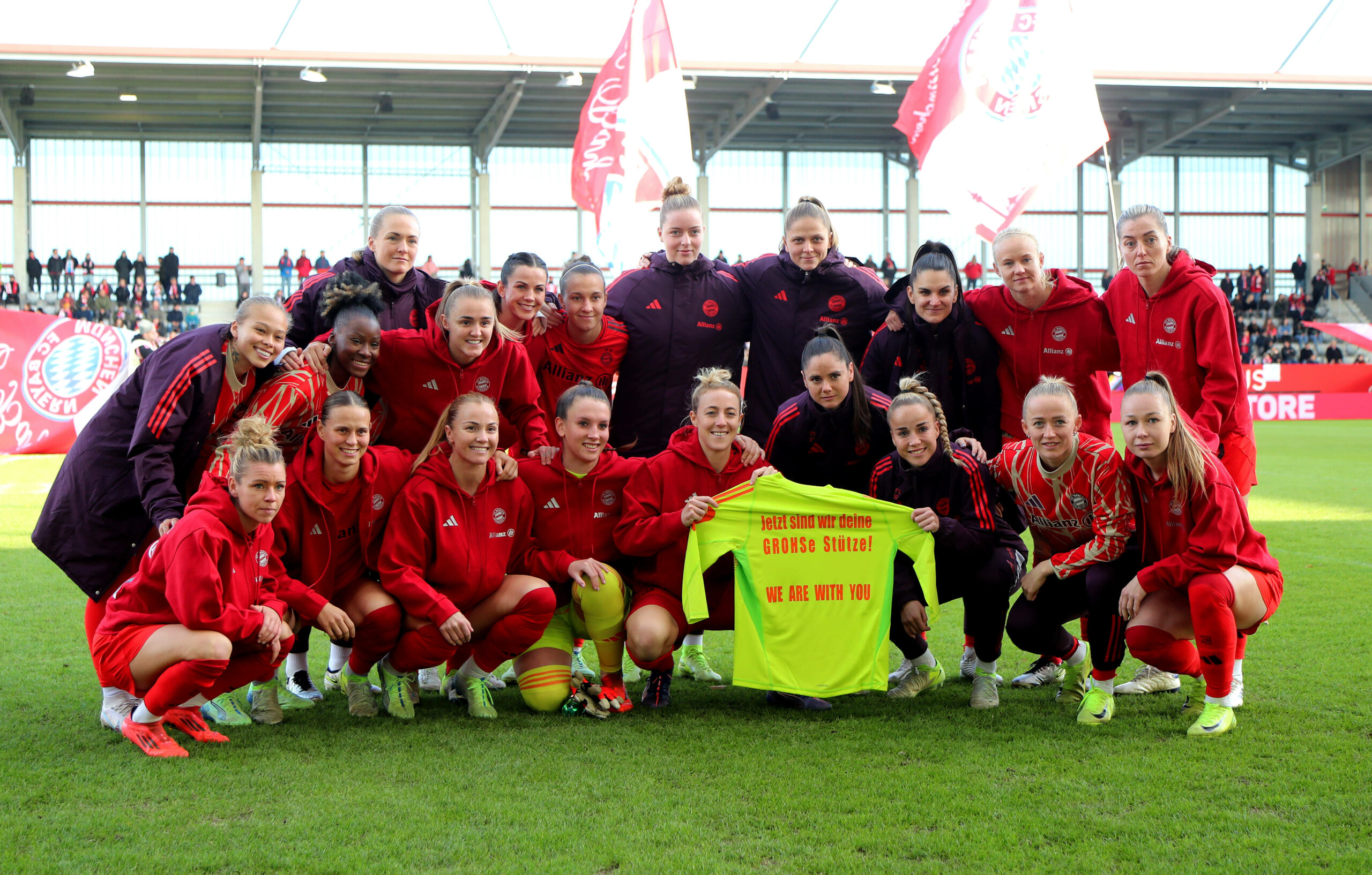 Die Spielerinnen des FC Bayern München posieren mit einem Shirt für Maria Luisa Grohs