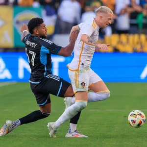 Marco Reus dribbelt mit dem Ball, Gegenspieler Carlos Harvey versucht ihn von hinten u stoppen.