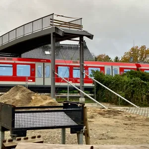 Brücke endet in der Luft, darunter fährt eine rote S-Bahn