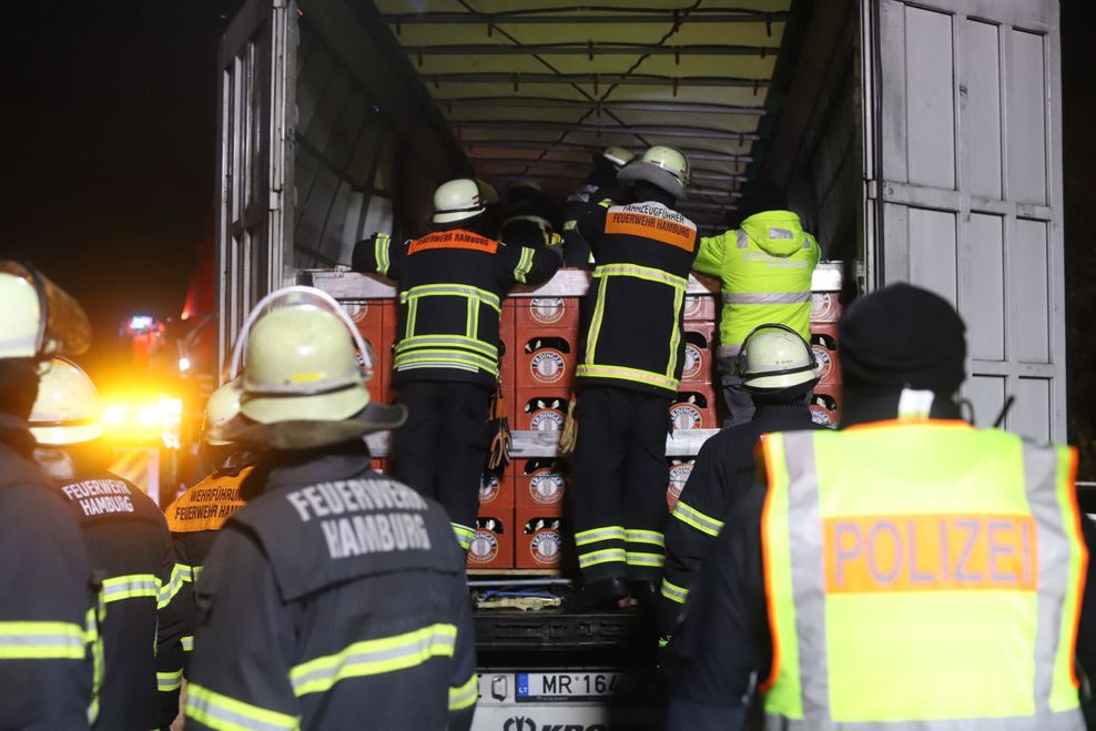 Die Feuerwehrleute haben die Bierkisten im Lkw wieder aufgerichtet.