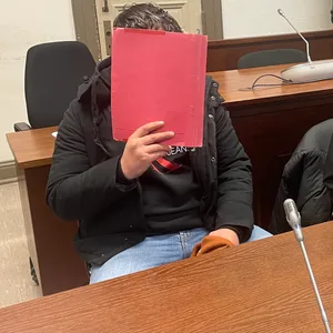 Der Angeklagte Alaaedin W. (34) sitzt zum Prozessbeginn neben seiner Verteidigerin. Sein Gesicht verbirgt er hinter einer Mappe.
