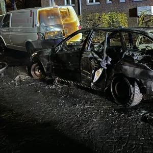 Das ausgebrannte Auto am Straßenrand.