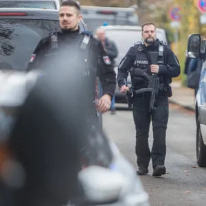 Polizisten an Streifenwagen
