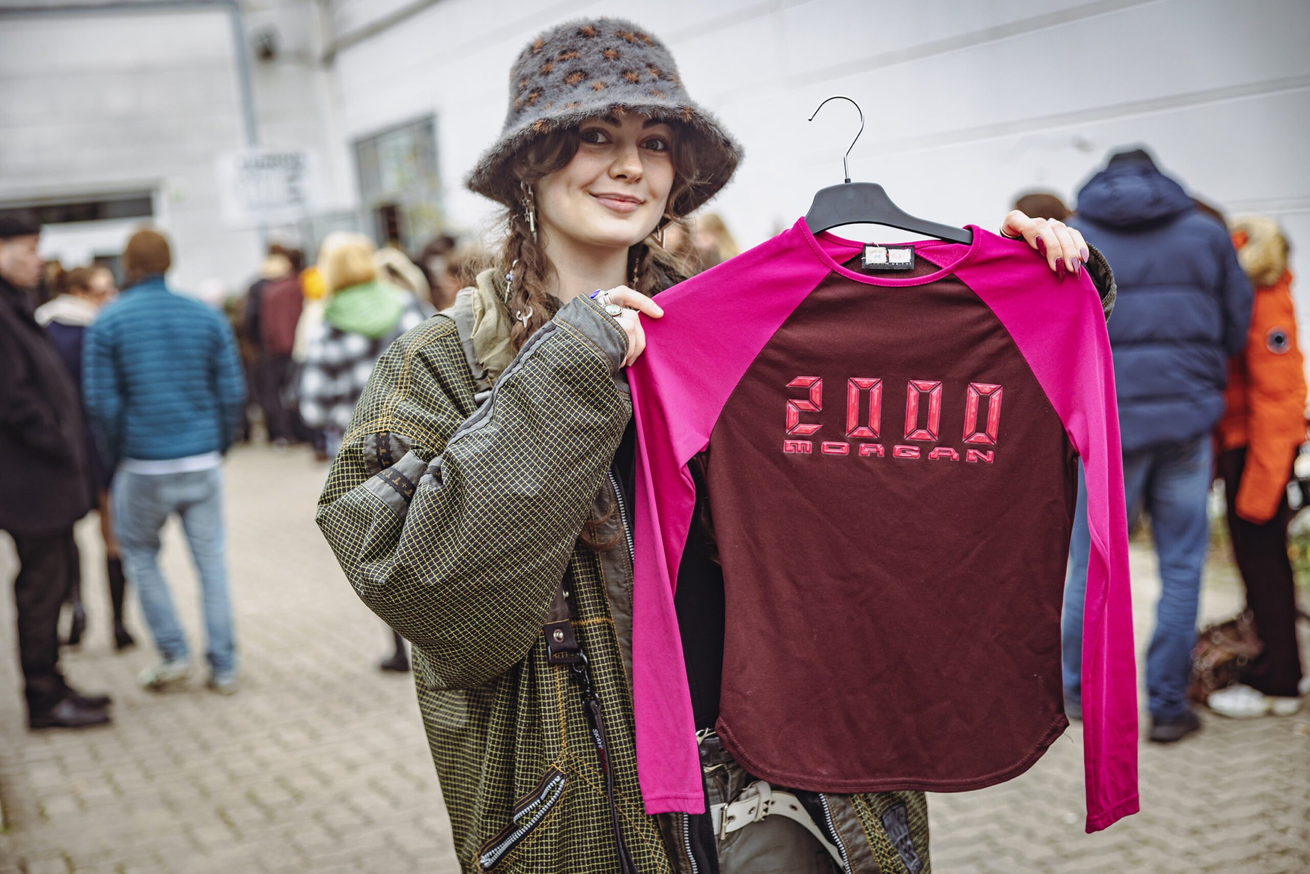 Marie (21) aus Rissen hält, das pinke Oberteil hoch, welches sie sich bei dem Ausverkauf des Fundus „Jacke wie Hose“ gekauft hat