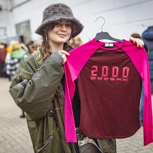 Marie (21) aus Rissen hält, das pinke Oberteil hoch, welches sie sich bei dem Ausverkauf des Fundus „Jacke wie Hose“ gekauft hat