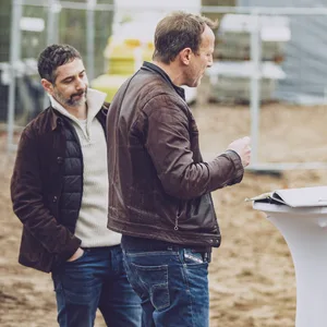 Schauspieler Wotan Wilke Möhring diskutiert mit Tatort-Regisseur Hans Steinbichler. Daneben stehen die Schauspielerin Esther Rolling