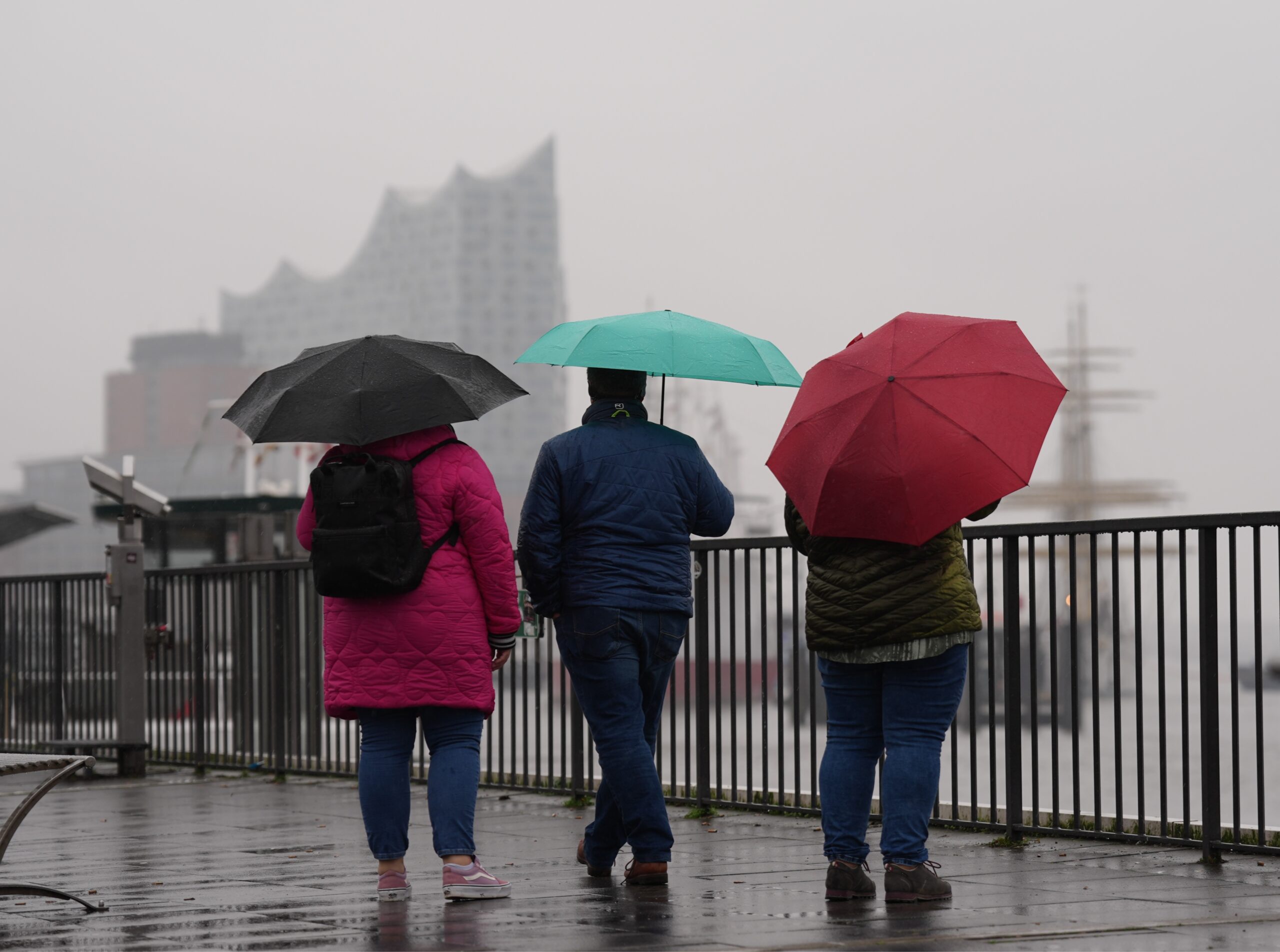 Leute mit Regenschirm an den Landungsbrücken