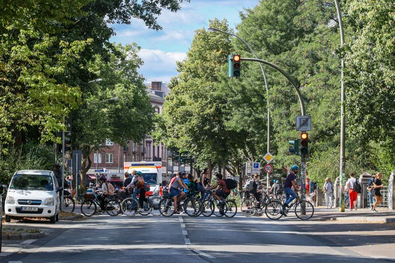 Verkehr auf der Bundesstraße. Fahrradfahrer überqueren Ampel