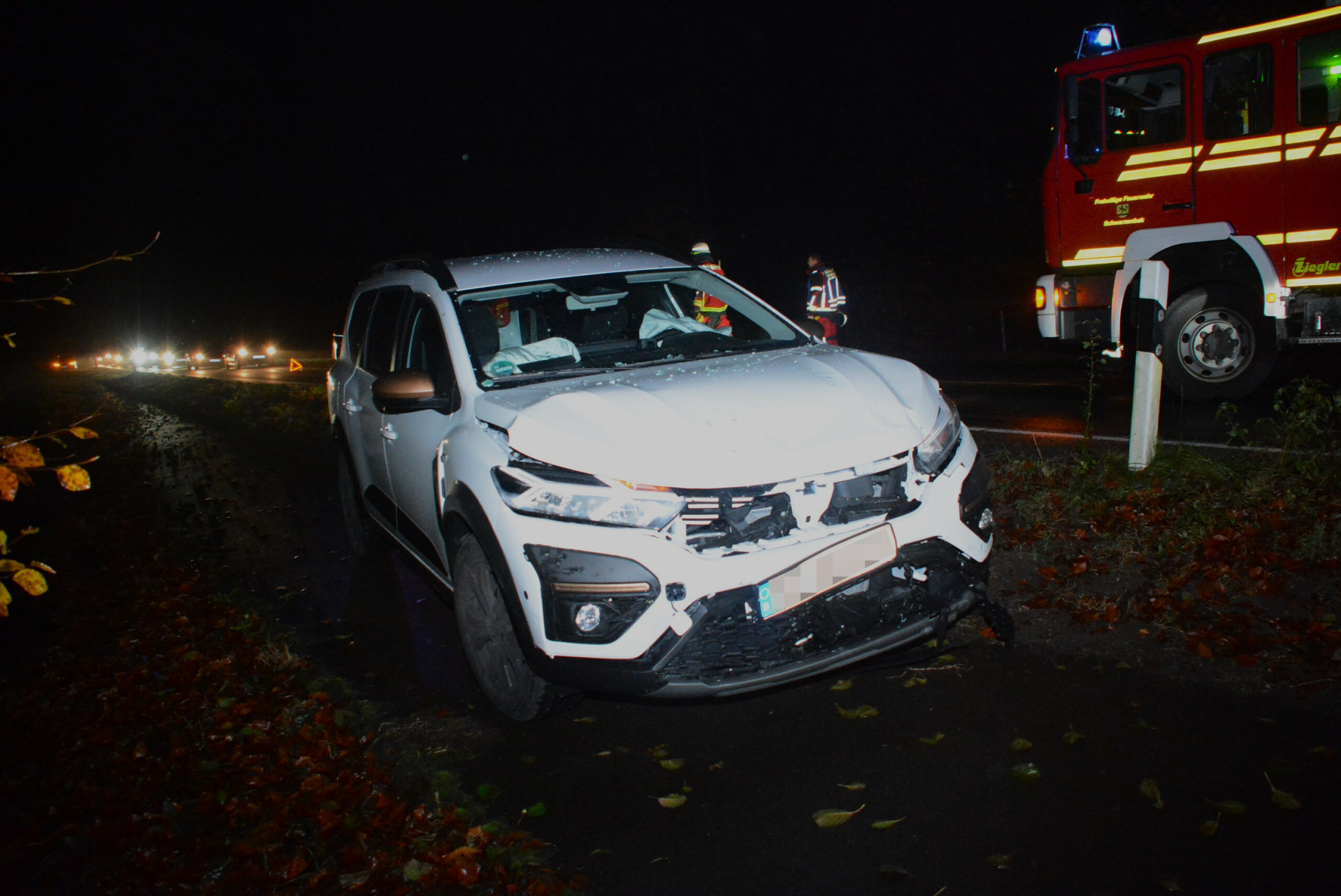 Ein weißes Auto mit Schäden an der Vorderseite und ausgelösten Airbags