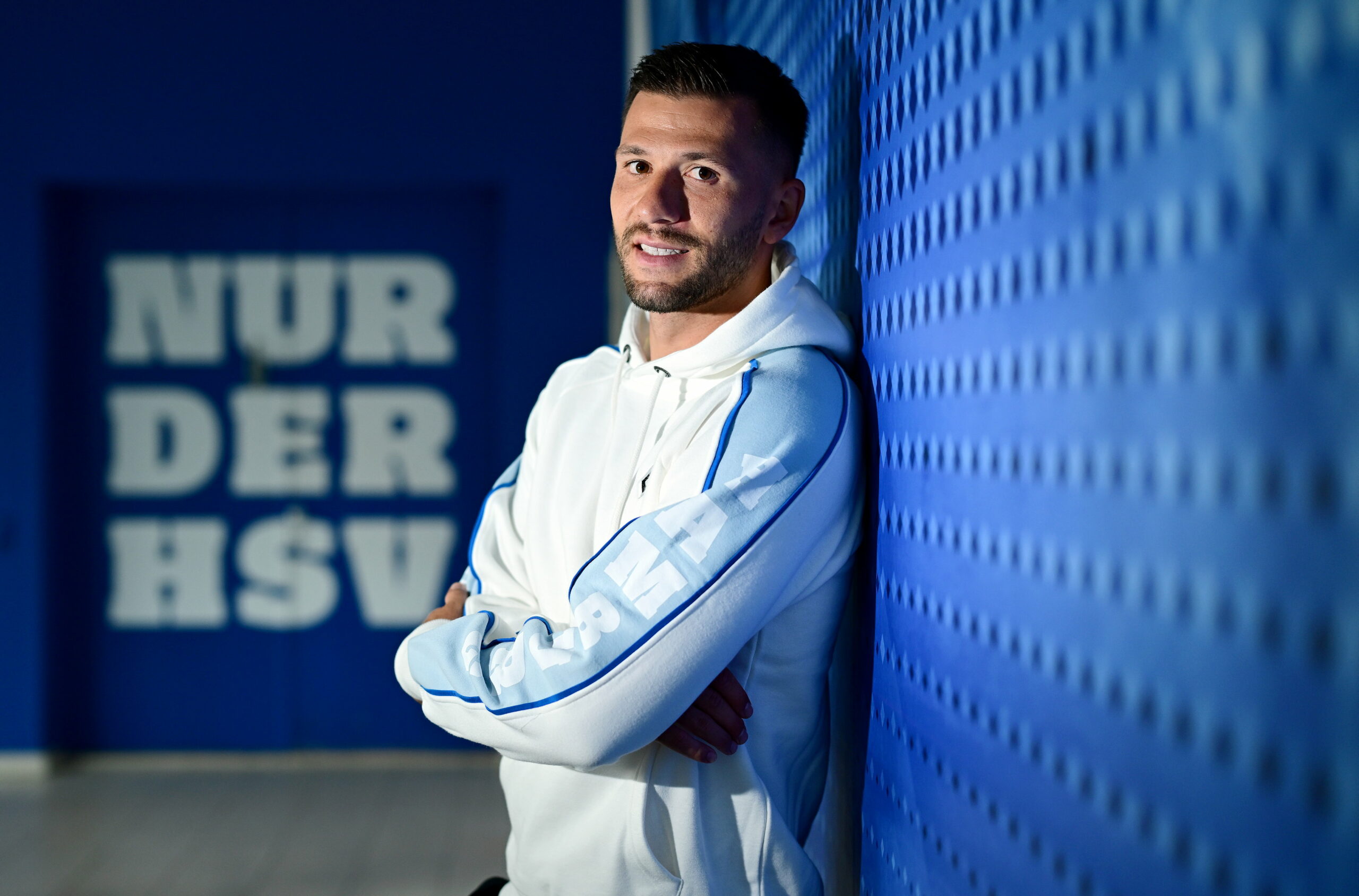 Daniel Heuer Fernandes lehnt sich an eine HSV-Wand