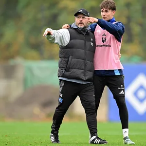 HSV-Trainer Steffen Baumgart und Nachwuchsstürmer Otto Stange zeigen in die gleiche Richtung.