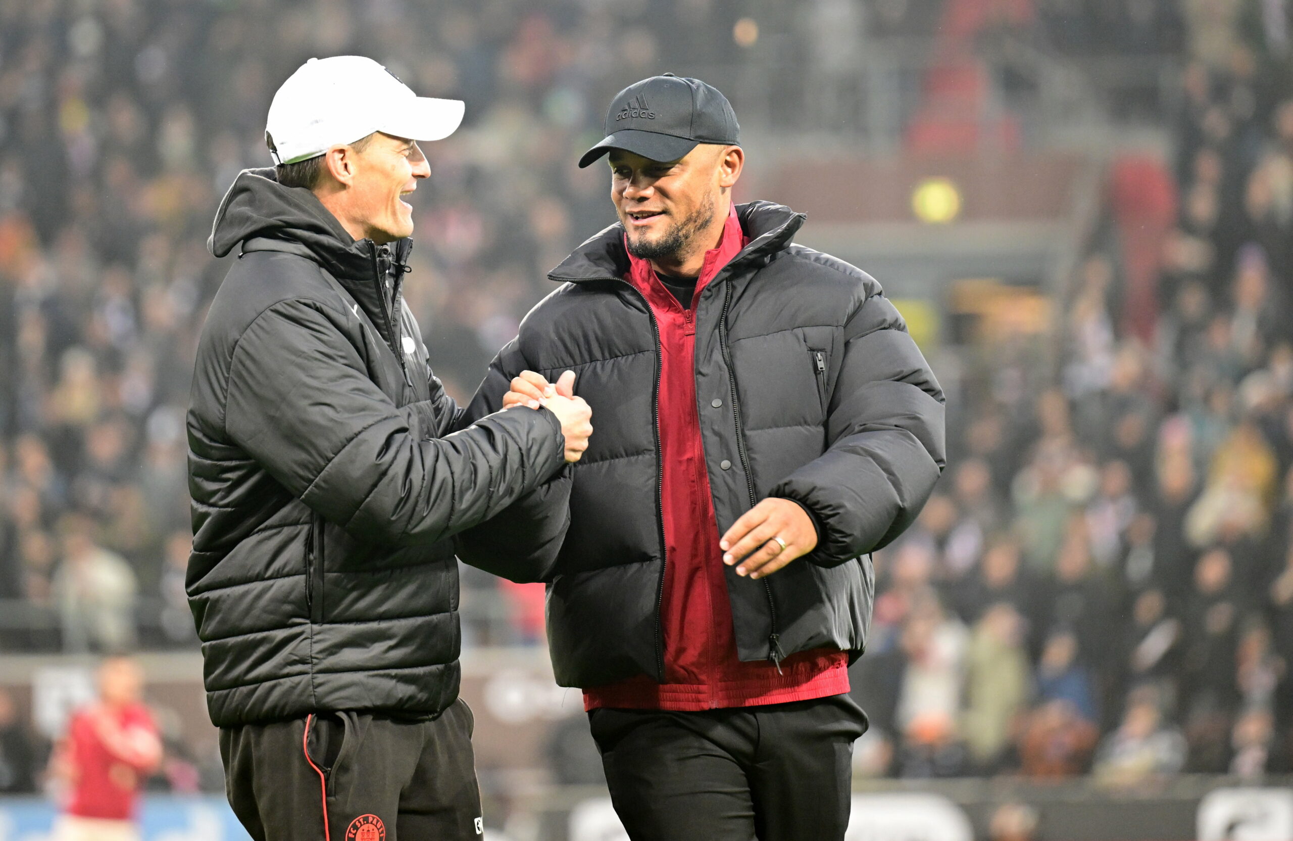 Bayern-Coach Vincent Kompany schlägt mit St. Paulis Trainer Alexander Blessin ein