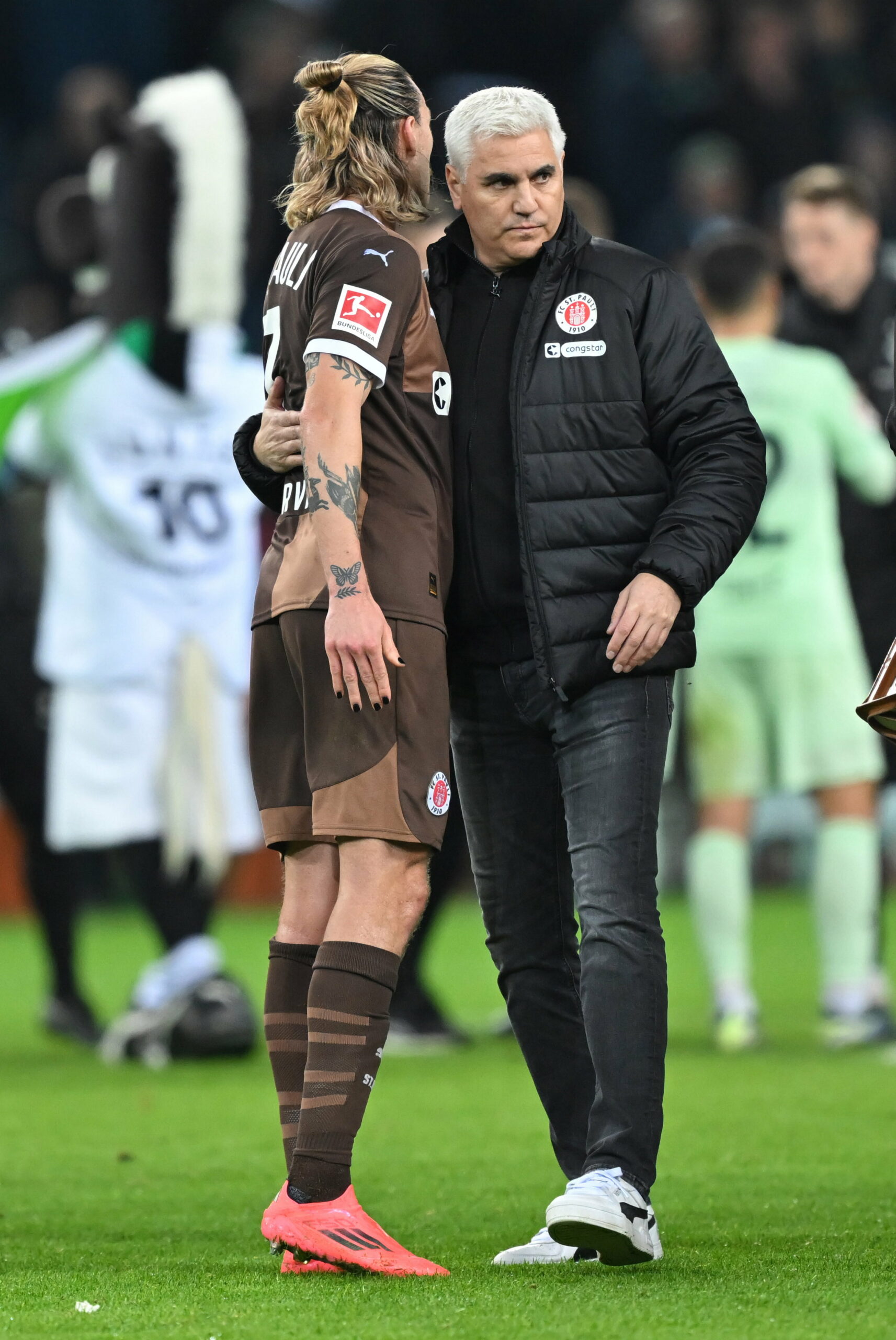 Andreas Bornemann umarmt Jackson Irvine auf dem Spielfeld in Gladbach