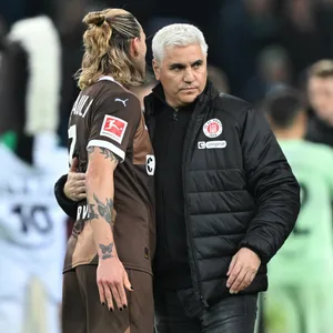 Andreas Bornemann umarmt Jackson Irvine auf dem Spielfeld in Gladbach