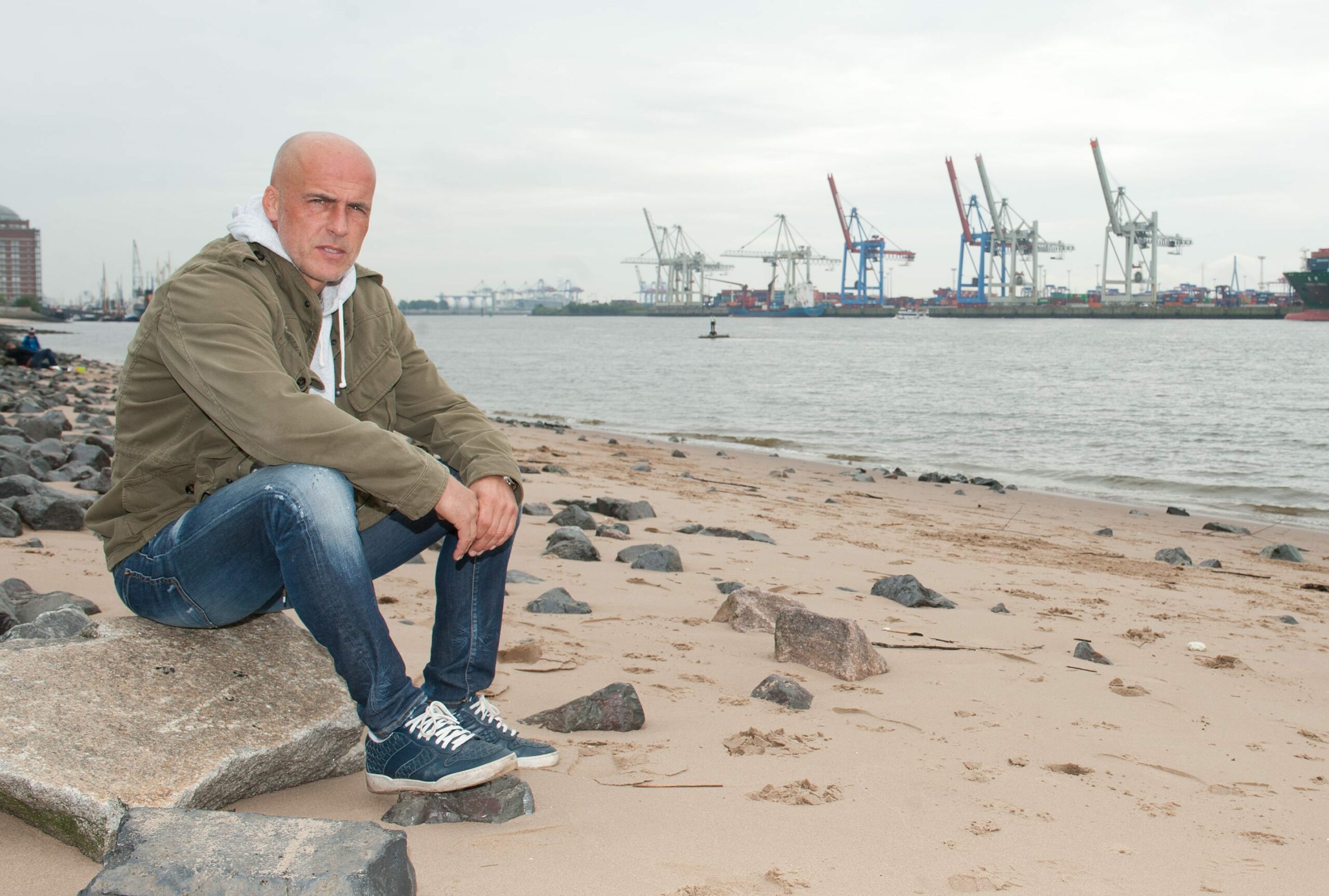 Michael Frontzeck sitzt am Elbstrand