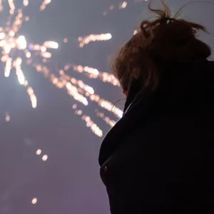 Eine Frau schaut sich das Silvesterfeuerwerk an.