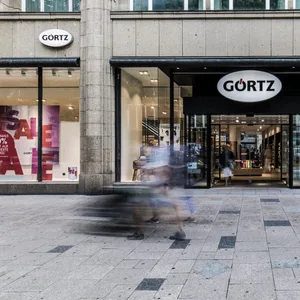 Menschen gehen durch die Innenstadt. Im Hintergrund ist die Görtz Filiale