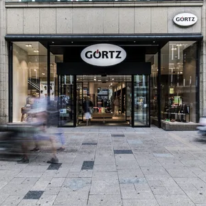 Menschen gehen durch die Innenstadt. Im Hintergrund ist die Görtz Filiale