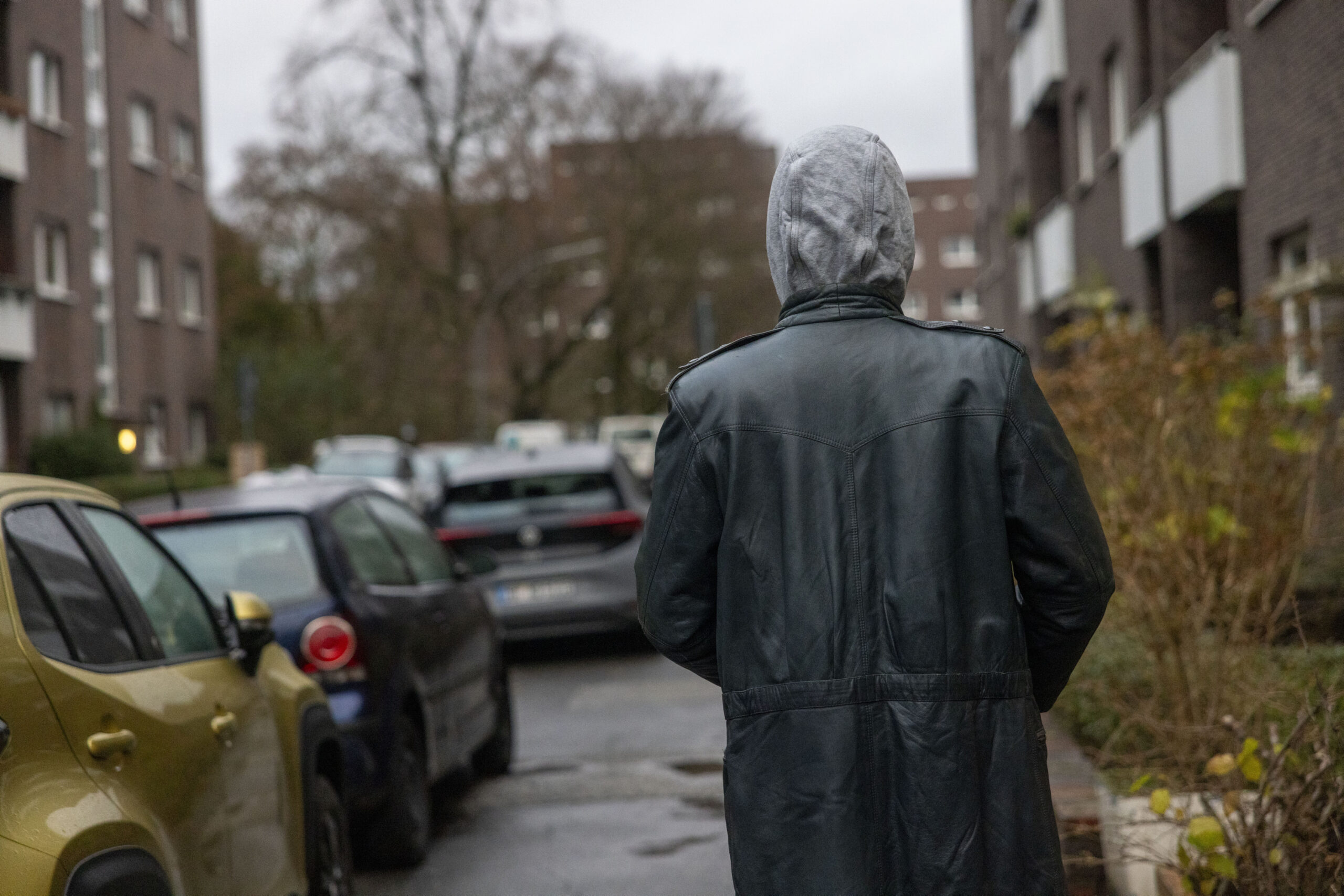 Corin (20) steht vor der „Hude“ an der Gottschedtstraße. Um seine Anonymität zu wahren, hat er sich einen Hoody und einen Mantel aus dem Fundus der Beratungsstelle übergezogen.