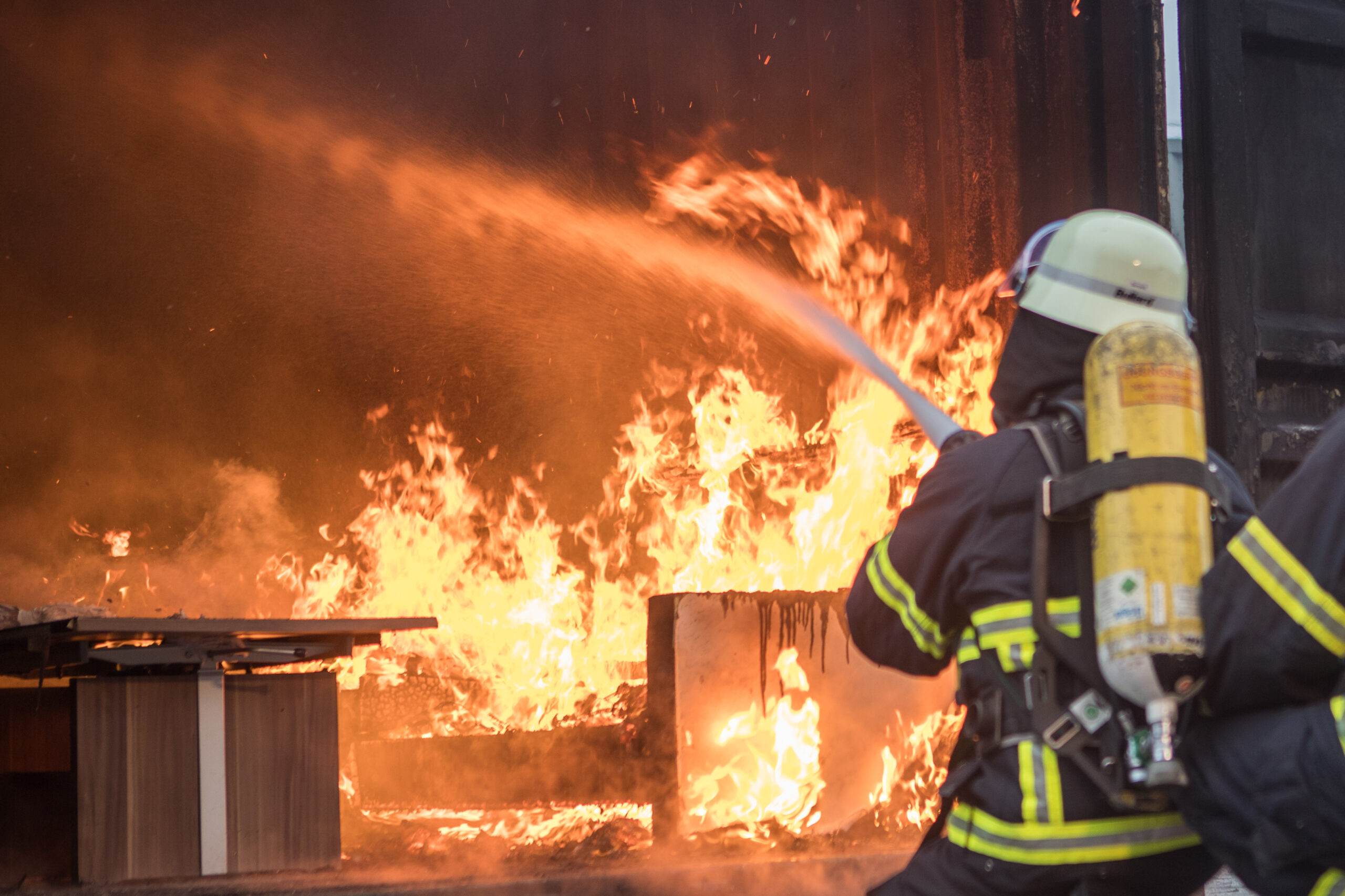 Mit einer bestimmten Löschtechnik (hier: Lassotechnik) wird das Feuer bekämpft. Bereits in der Ausbildung lernen die Feuerwehrleute bei einem Brand so wenig Wasser wie möglich einzusetzen, um einen Wasserschaden zu vermeiden.