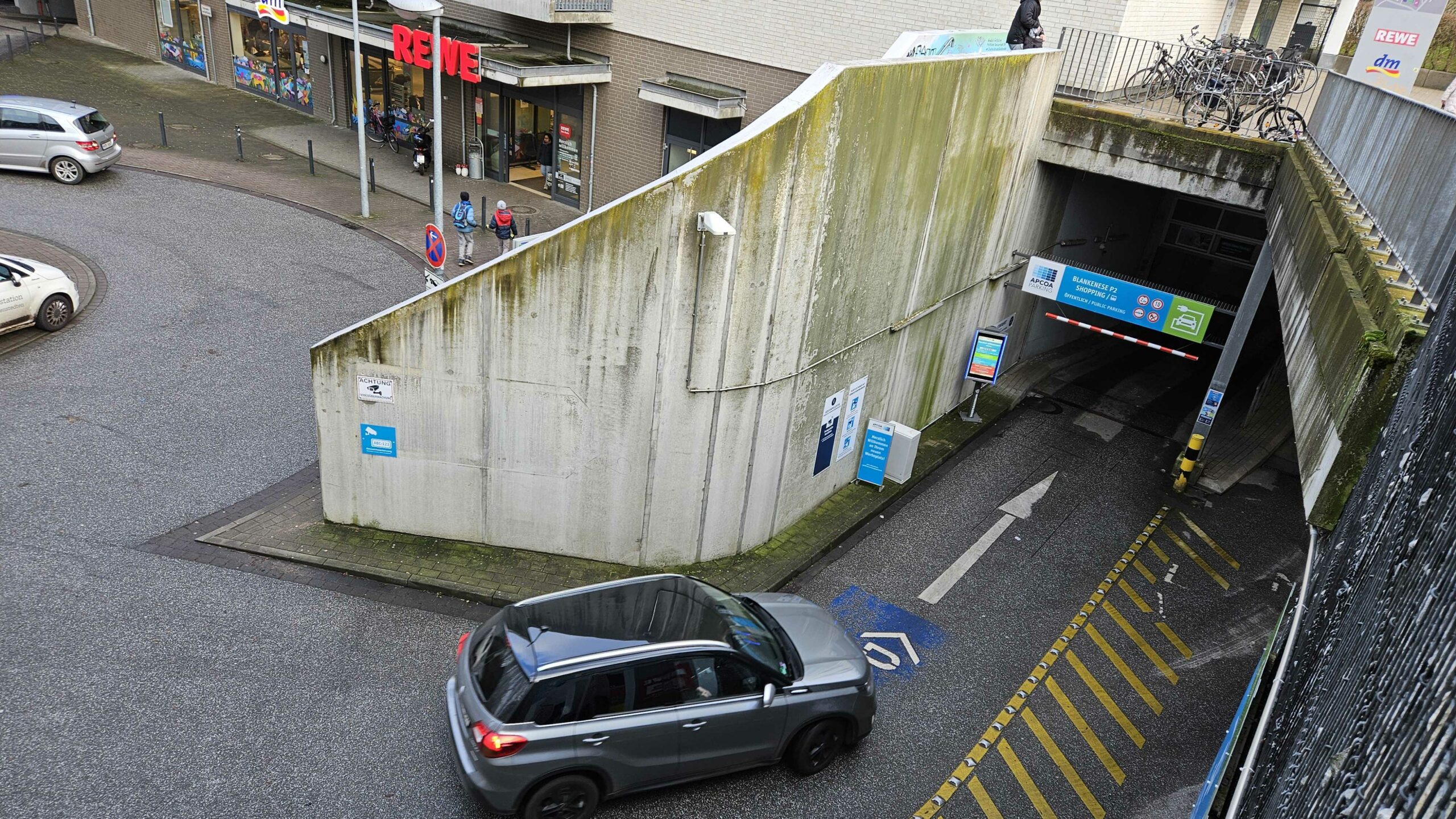 Autos fahren in Parkhaus neben Rewe.