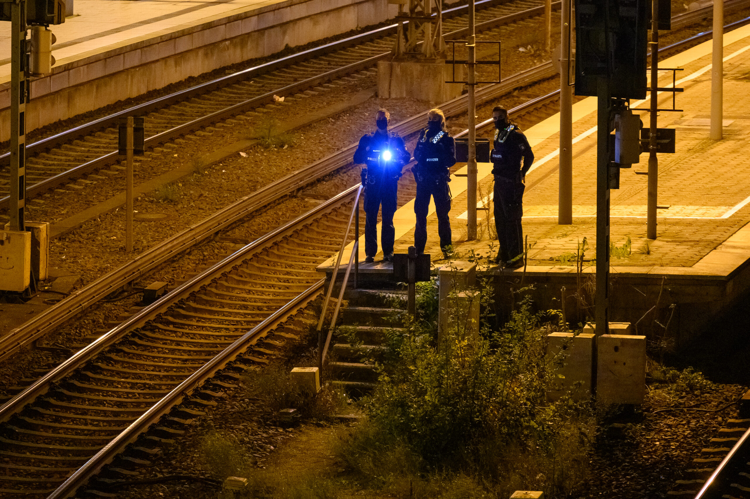 Mit Taschenlampen suchen Bundespolizisten den Gleisbereich ab. (Symbolfoto)