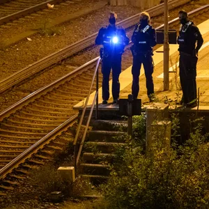 Mit Taschenlampen suchen Bundespolizisten den Gleisbereich ab. (Symbolfoto)