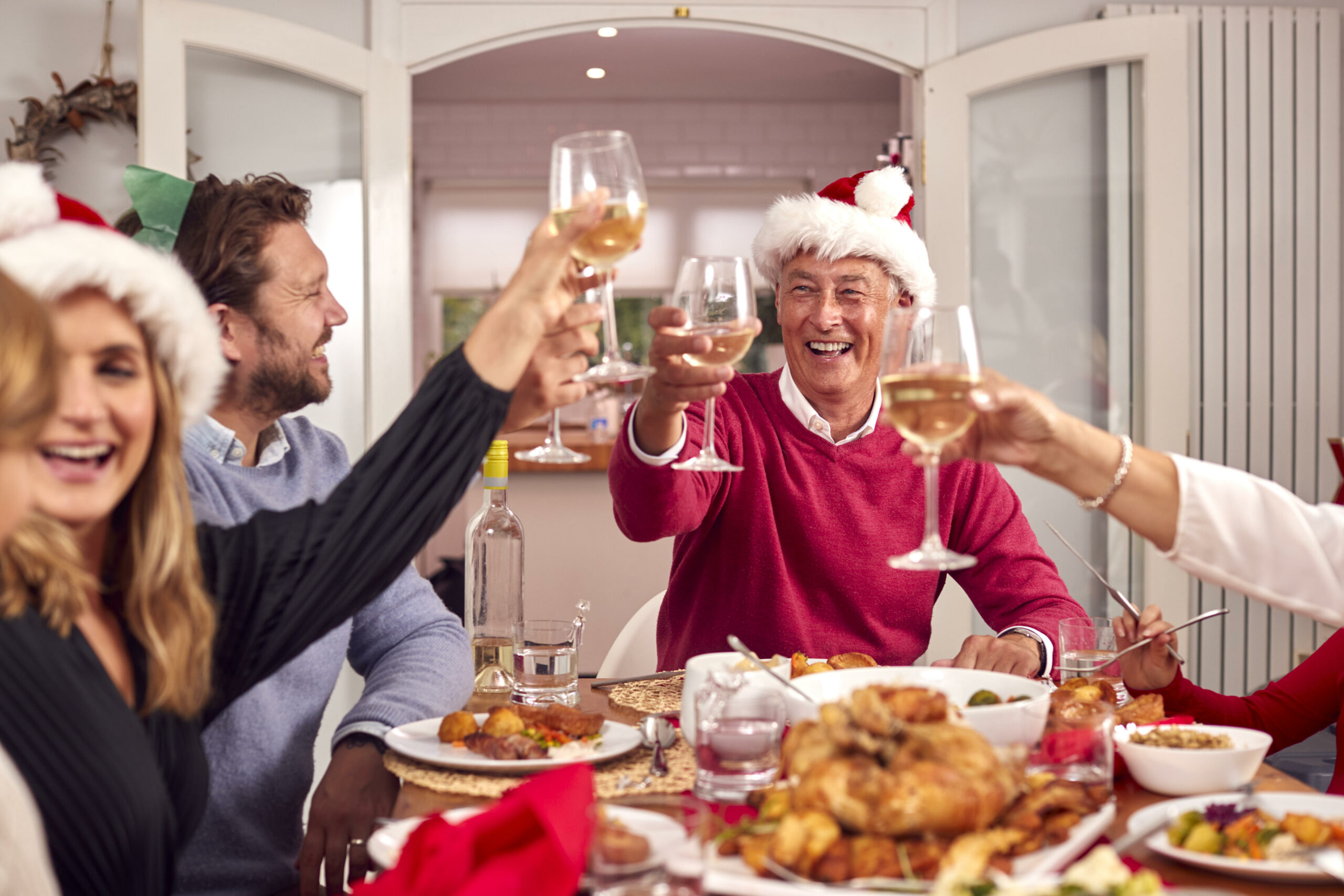 Eine Familie sitzt an einem weihnachtlich gedeckten Tisch