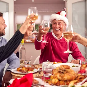 Eine Familie sitzt an einem weihnachtlich gedeckten Tisch