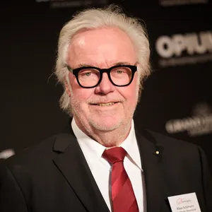 Weißhaariger Herr mit Schlips und Brille