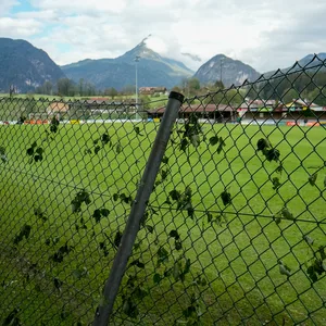 Hinter einem Zaun liegt ein Fußballplatz in Österreich