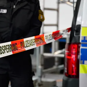 Ein Polizeibeamter steht hinter einer Polizeiabsperrung (Symbolbild)