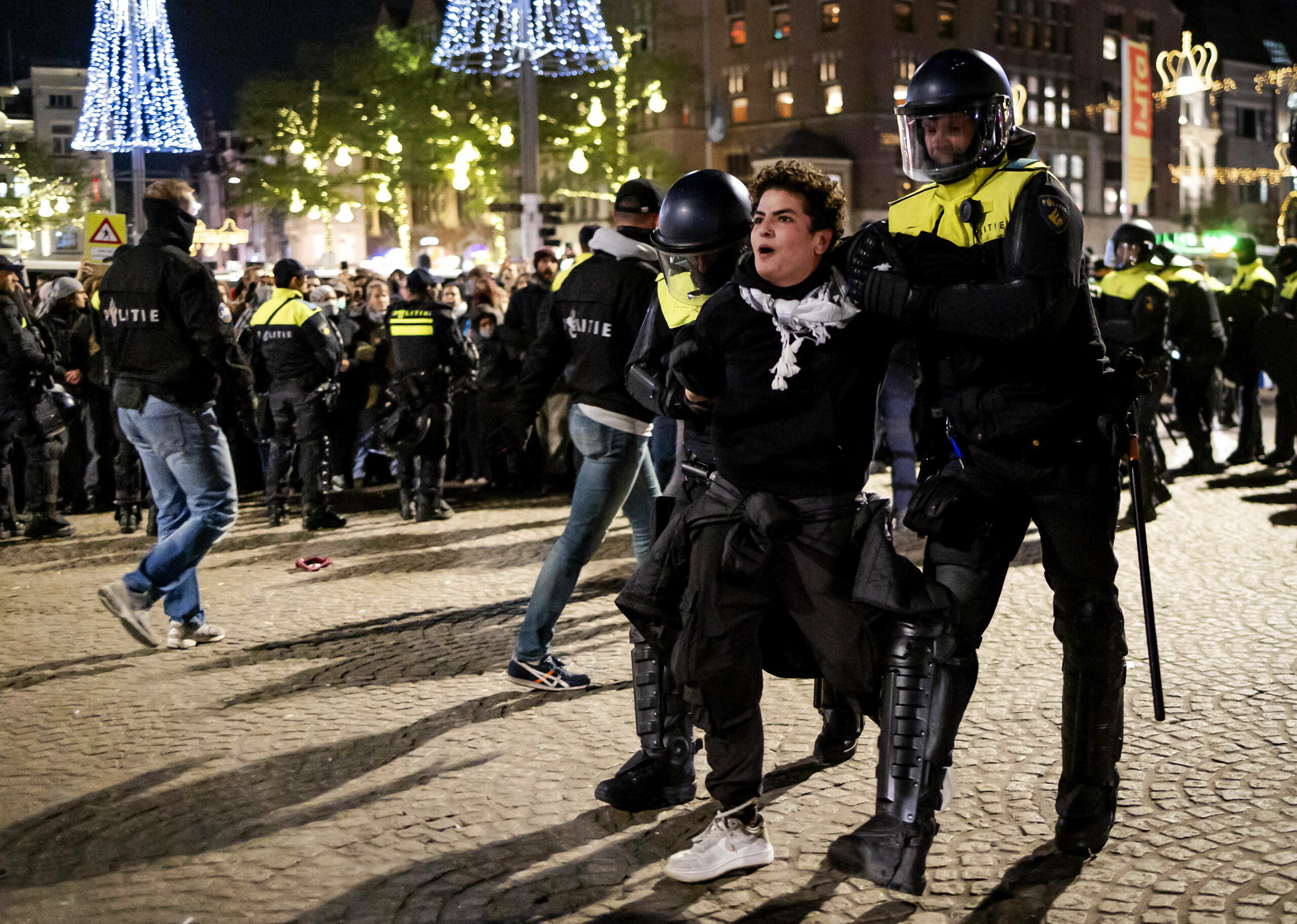 Ein Fan wird von zwei Polizisten festgehalten